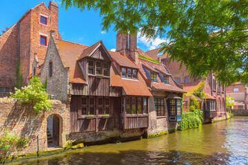 Quaint stone houses with romantic view of canal and old town of Bruges, Belgium
