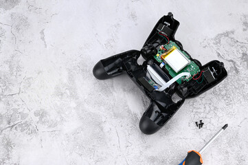 Black game controller disassembled, The concept of repairing game console electronics. Place for the text.