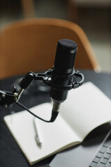 Vertical close up shot of black condenser microphone prepared for podcast interview in recording...