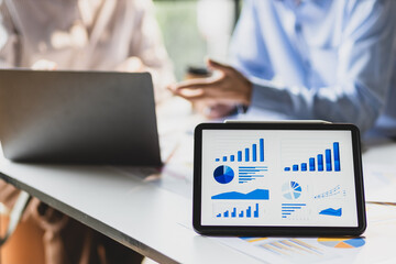 Business growth graphs and charts discussion meeting on modern digital tablets and financial planning for investments. Strategy analysis and business planning.