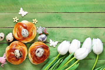 Easter buns and traditional eggs on wooden background
