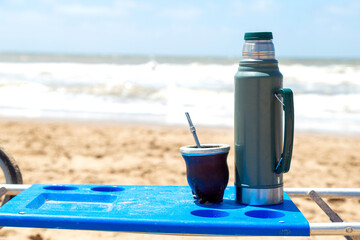 Yerba mate infusion typical of South America. Pumpkin Mate accompanied by the thermos on the beach.