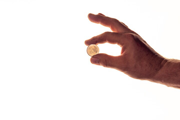 Hand eines Mannes hält 2 Euro Münze zwischen Daumen und Zeigefinger, weißer Hintergrund,...