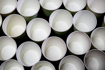 White empty paper cups on a black background. Texture of cups