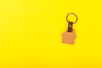 House keys with a keychain in the shape of a house on a colored background.Design element.Real estate and insurance concept.Copy space. Rent, sale or purchase of real estate.