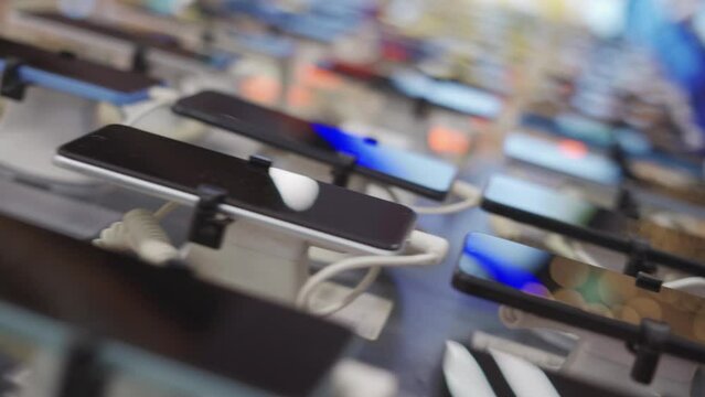 A lot of smartphone models on display at the exhibition stand of an electronics store