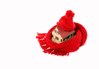 old model house wrapped with red scarf and cap, thermal insulation saves heating costs