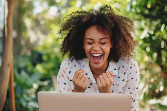 Excited young woman looking at laptop screen. Beautiful overjoyed girl feeling happy about her work.
