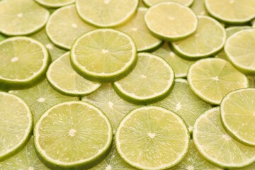 Many juicy lime slices as background, above view