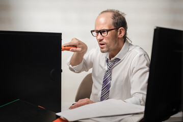 Frustrated office worker trying to fix his broken pc with screwdriver, Man's ire flares as he...