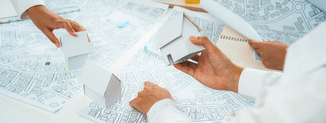 Fototapeta na wymiar Worker, architect and engineer work on real estate construction project oratory planning with cartography and cadastral map of urban town area to guide to construction developer business plan of city