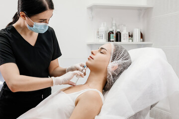 Injection procedure. The cosmetologist slowly and carefully injects filler into the client’s...