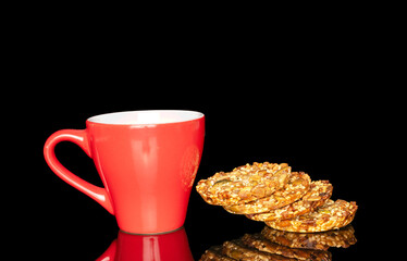 Several sweet Thaler cookies with red ceramic cup, macro, isolated on black background.