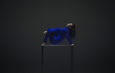 Portrait of female acrobat isolated on black background. Woman gymnastic dancer in blue sparkling...