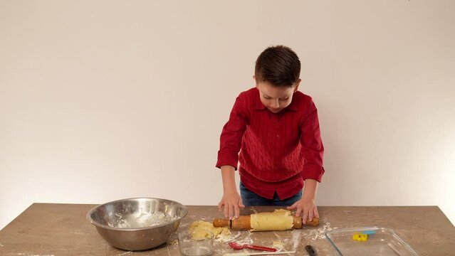 ni&ntilde;o amasando la masa para hacer y hornear galletas para compartir con su familia y sus amigos