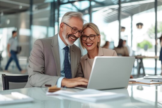 Two business people looking at a laptop and smiling
