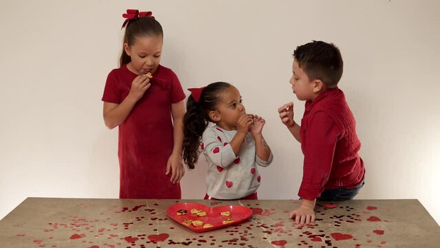 Ni&ntilde;os felices hermanos amigos comiendo galletas rico postre compartiendo como familia unida divertidos y alegres disfrutando de unos ricos bocadillos juntos