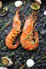 King prawns on black rice decorated with clams and parsley