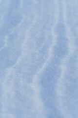 Obraz premium Snow after wind forms white canvas swirling patterns. Light, sparkling, with ice crystals. Unique natural texture and tranquility winter landscape.
