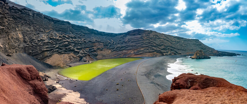 Stunning view of the imploded volcano caldera on the shores of the island of Lanzarote, Canary Islands. On the left the green lagoon at the center of the volcano