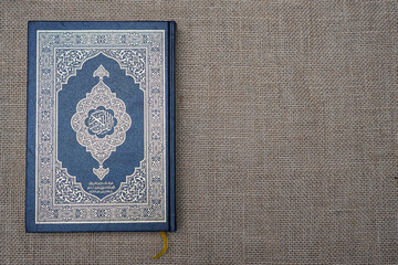 The Quran, also romanized Qur'an or Koran, is central religious text of Islam, believed by Muslims to be revelation from God (Allah). Classical Arabic. Sack, blue.