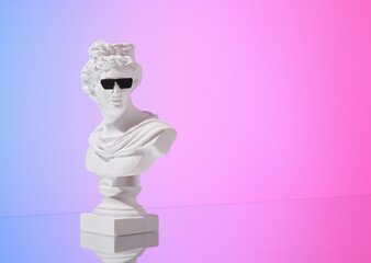 A gypsum statuette and black sunglasses. Copy space for text.