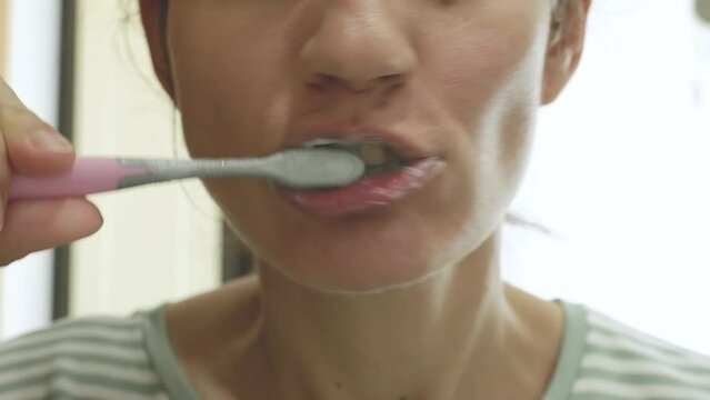 Close-up of a woman's mouth. A woman brushes her teeth with a toothbrush and toothpaste. concept of hygiene and health of teeth and oral cavity. daily care and brushing of teeth