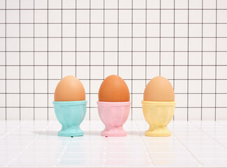 Three eggs in colorful stands. Healthy breakfast and diet.