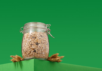 Breakfast cereal in a glass jar and wheat. Copy space for text.