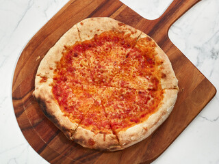 Fresh cheese pizza with thick crust on a wooden peel
