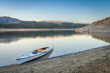 Fototapeta na wymiar expedition canoe on a shore of Carter Lake in northern Colorado, warm winter afternoon