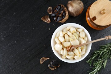 Flat lay composition with fresh and fermented black garlic on table. Space for text