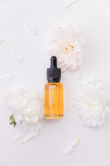 Obraz na płótnie Canvas Cosmetic nature oil organic for skincare. Pipette bottle with serum and flowers on white background, place for product, top view