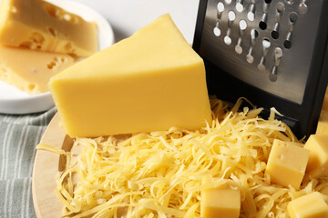Grated and whole pieces of cheese on table, closeup