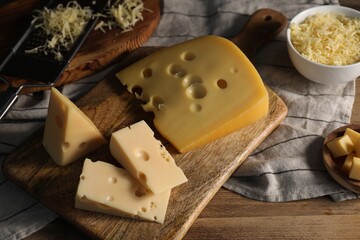 Grated, cut cheese and grater on wooden table