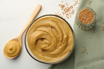 Tasty mustard sauce and dry seeds on white table, flat lay