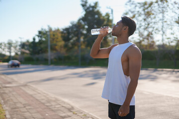 Asian man drinking water after exercising outdoor.