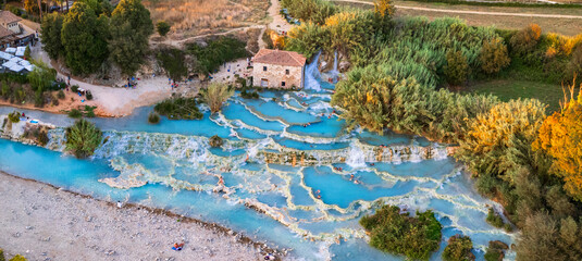 Most famous natural thermal hot spings pools in Tuscany - scenic Terme di Mulino vecchio ( Thermals of Old Windmill) in Grosseto province.  high angle drone view - 724008961