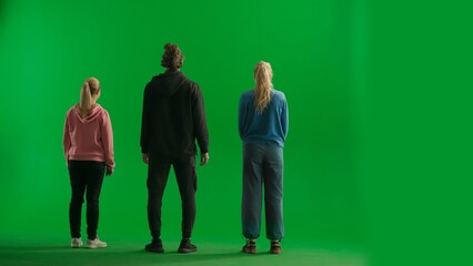 Back view of a team of three hikers looking out and admiring the view. A group of people in a studio on a green screen. Travel concept.