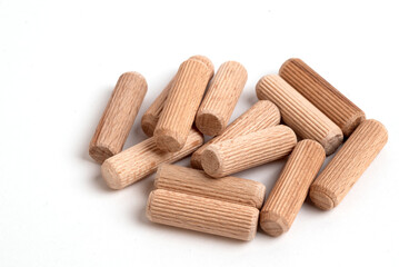 Pile of wooden dowels on the white background.
