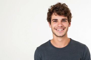 Portrait of a handsome young man smiling at the camera while standing against white background