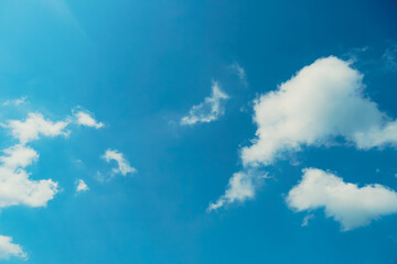 Clear blue sky background. Clear blue sky panoramic background with small white clouds. Clouds in a bright blue sky