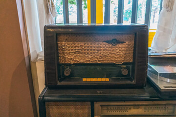 Ancient radio lay on the shelves. Radio on cabinet next to plant. Real photo. retro radio. antique radio.
