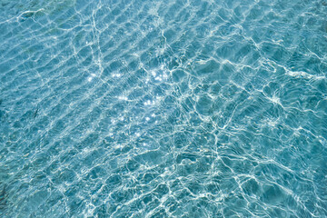 Detail of a sunlight reflecting in glittering sea. sparkler in water background. sea water with sun glare and ripple. Powerful and peaceful nature concept. Sea water surface background