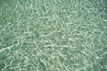 Detail of a sunlight reflecting in glittering sea. sparkler in water background. sea water with sun glare and ripple. Powerful and peaceful nature concept. Sea water surface background