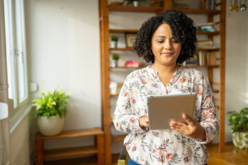 Smiling woman using digital tablet at home office