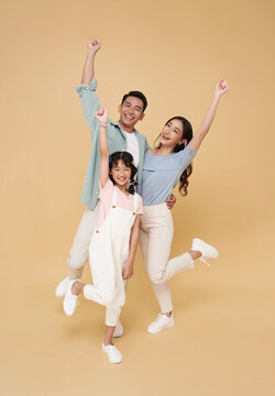 Portrait happy smiling Asian family celebrate winner together isolated on nude color background.