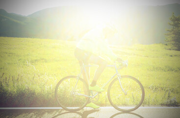 unrecognizable cyclist with racing bike on the road in backlight ideal as a background for sports...