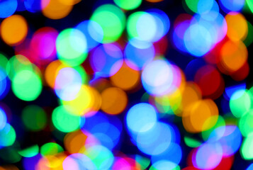 intentionally blurred background of many colorful lights of many colors yellow orange blue green ideal as a hyptonic background