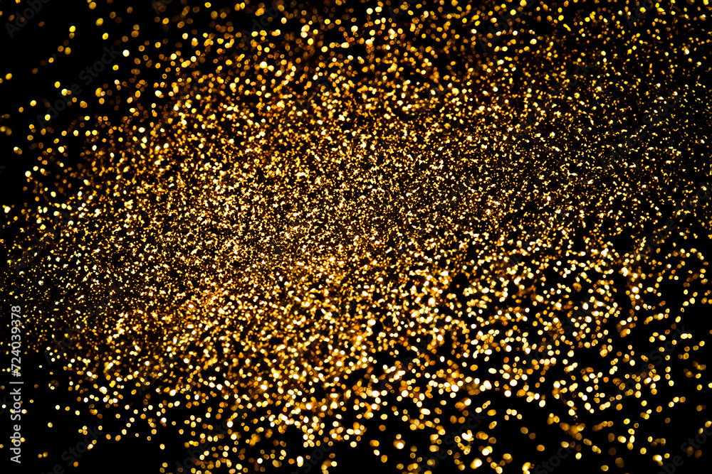 Wall mural Gold glitter on black background.